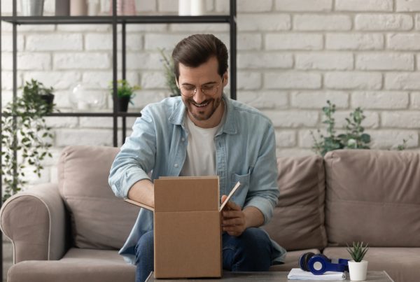 Unpacking,Parcel.,Happy,Young,Man,Postal,Delivery,Service,Client,Sit